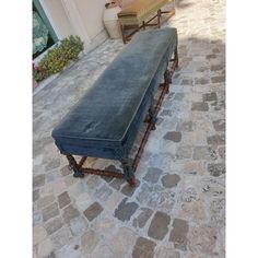 a long bench sitting on top of a stone floor