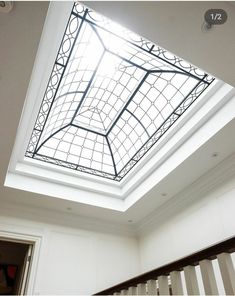 an open skylight in a white room with railings and hand rails on the stairs