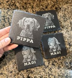 three black and white dog coasters with the words pippa printed on them are being held by a person's hand