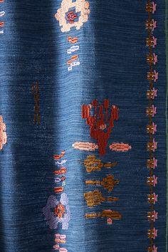 a close up of a blue fabric with flowers and cactuses on the back side