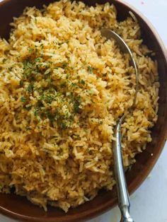 a brown bowl filled with rice and garnished with parsley