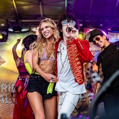 two people dressed in costumes standing next to each other on the dance floor at a party