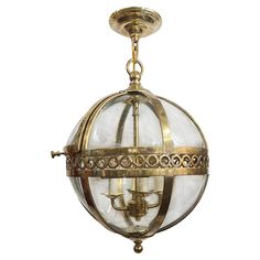 an antique brass chandelier with clear glass globes hanging from it's ceiling