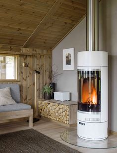 a living room with a wood burning stove in the center and a couch next to it