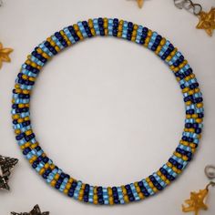 a necklace made with beads and stars on a white table next to other jewelry items