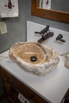 a bathroom sink made out of an old tree stump with rope on the edge and soap dispenser next to it