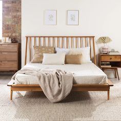 a bed sitting in a bedroom next to a wooden dresser and chest of drawers