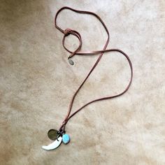 "-This earthy unisex necklace features a coyote tooth, a Peruvian blue opal stone, and an antique wheat penny. -The trio hangs from adjustable deerskin leather lace, which is 30\" from end to end. Just tie the leather in a bow or knot at the desired length. -Layers well with longer necklaces and looks great on men or women. -Dates on antique coins will vary. -Each opal stone and tooth are unique. Opals may vary in size and color, but each are beautiful and hand-picked by the designer. -No animal Long Adjustable Necklace For Festival, Adjustable Long Festival Necklace, Festival Pendant Necklace With Adjustable Cord, Handmade Waxed Cord Necklace For Everyday, Adjustable Cord Lariat Necklace For Festivals, Festival Lariat Necklace With Adjustable Cord, Everyday Bohemian Necklace With Adjustable Length, Adjustable Pendant Necklaces With Waxed Cord, Adjustable Pendant Necklace With Waxed Cord