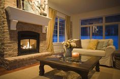 a living room filled with furniture and a fire place in front of a large window