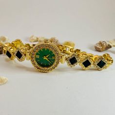 Discover the epitome of elegance with this gold women's watch, a stunning piece that seamlessly blends classic luxury with modern style. Featuring a vibrant emerald green dial surrounded by sparkling crystals, this unique watch for women is perfect for those who appreciate vintage-inspired designs. Whether you're looking for a dainty women's watch that adds a touch of sophistication to your outfit or a statement piece that stands out, this timepiece delivers it all. ✈All Orders Express Shipping Elegant Green Luxury Watch Bands, Metal Watch Accessories With Round Dial For Gift, Diamond Watch With Metal Dial, Metal Diamond Watch With Metal Dial, Metal Diamond Watch, Gold Watches With Rhinestones, Gold Round Watch With Rhinestones, Gold Round Watches With Rhinestones, Metal Round Watch Accessories For Gift