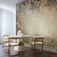 an elegant dining room with floral wallpaper and marble tables, gold chairs and vases