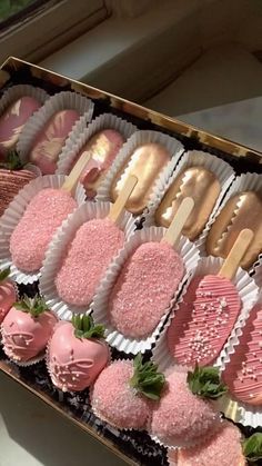 a box filled with lots of pink desserts