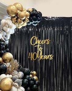 a black and gold balloon arch with the words cheers to 40 years written on it