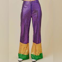 a woman in purple and gold pants with her hands on her hips