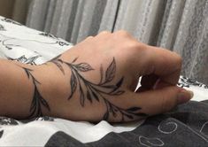 a person's arm with a tattoo on it and a hand holding the wrist