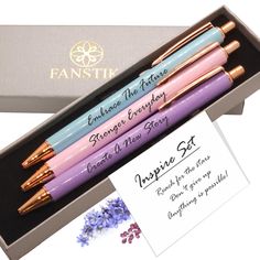 three pens in a gift box with an envelope and note inside the box, along with two greeting cards