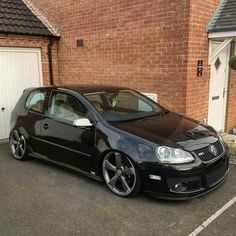 a black car parked in front of a brick building