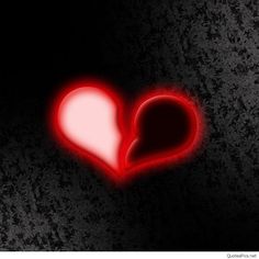 a red heart shaped object on a black background