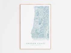 the oregon coast map is shown in light blue on a white wall with a wooden frame