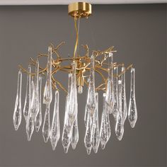 a gold chandelier with clear glass drops hanging from the ceiling