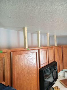 a kitchen with wooden cabinets and a microwave in the middle is being built into the wall