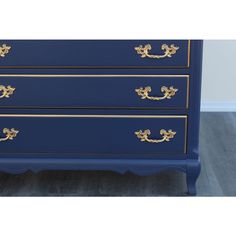 a blue dresser with gold trim and handles