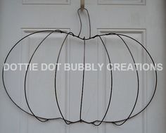 a wire pumpkin hanging on the front door with words dottie dotty bubba creations