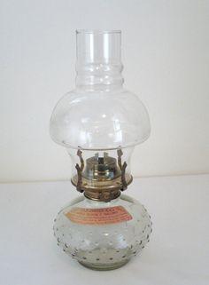 an old fashioned oil lamp sitting on top of a table