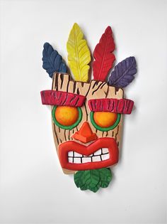 a wooden mask with colorful leaves on it