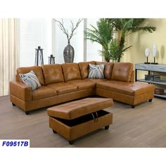 a brown leather sectional sofa sitting on top of a hard wood floor next to a plant