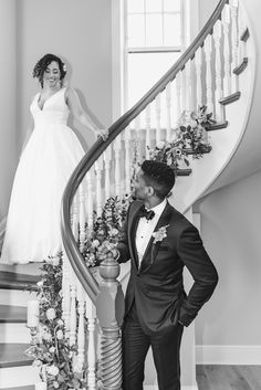 a bride and groom are standing on the stairs at their wedding reception in black and white