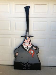 a statue of a man with a top hat and cane in front of a garage door