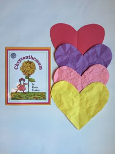 four heart shaped paper pieces next to a children's book