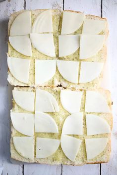 two slices of bread with cheese on them sitting next to each other, cut into squares