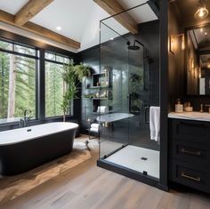 a black and white bathroom with a tub, sink, toilet and large glass windows