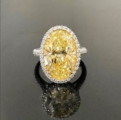 a fancy yellow diamond ring sitting on top of a table