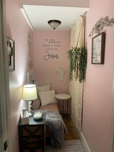 the hallway is painted pink and has a small table with a lamp on it next to a couch