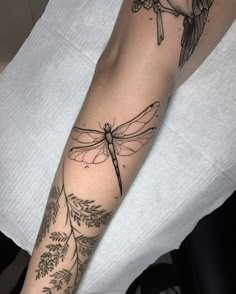 a woman's arm with a dragon tattoo on it, and an olive branch