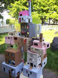 several cardboard houses are stacked on top of each other