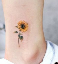 a small sunflower tattoo on the side of a woman's neck and leg