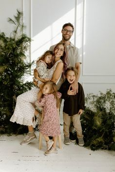 a family posing for a photo in front of a christmas tree