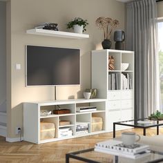 a flat screen tv sitting on top of a white entertainment center in a living room