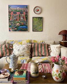 a living room filled with lots of furniture and flowers on the coffee table in front of it