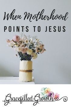 a vase filled with flowers sitting on top of a table next to a sign that says when motherhood points to jesus