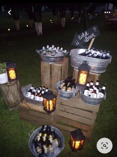 several buckets filled with bottles of wine sitting on top of a wooden pallet