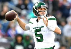 a man in a green and white uniform throwing a football