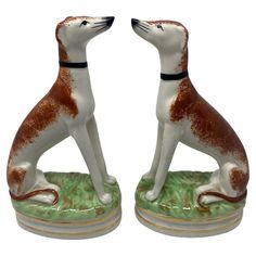 two ceramic figurines of dogs sitting next to each other