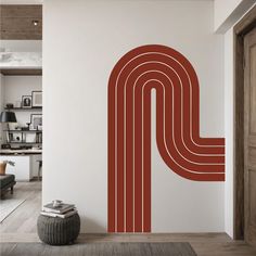 a room with a wall that has a large red letter p on it and a rug in front of it