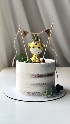 a white cake with a giraffe decoration on top