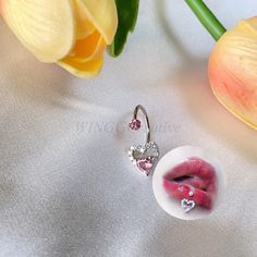 a close up of a pair of earrings on a table next to tulips